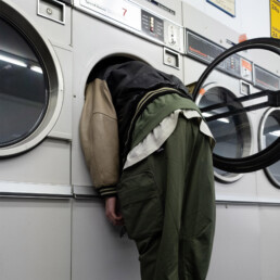 En person sticker in sitt huvud i en tvättmaskin